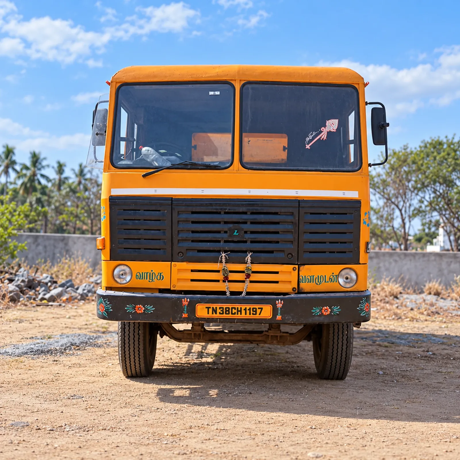 SRV AND CO orange heavy tipper truck viewed from the front