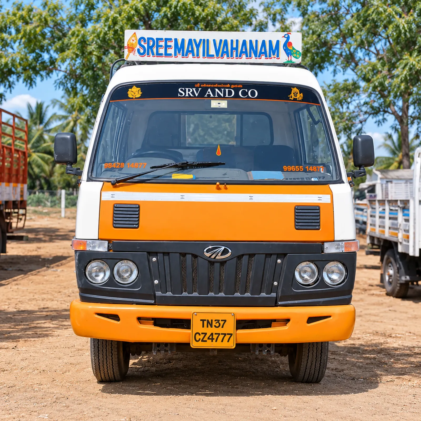 SRV AND CO orange Mahindra truck in the yard
